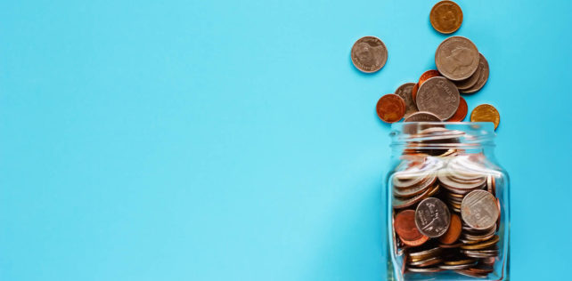 Coins in glass jar and outside, Thai currency money on blue background for business and finance concept Management package au profit du cadre d’une filiale : y a-t-il nécessairement acte anormal de gestion ?