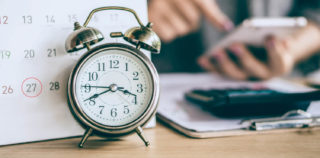 due date calendar and alarm clock with blur business woman hand calculating monthly expenses during tax season. Nouvelle convention collective de la Métallurgie : Le forfait annuel en jours (Episode 9)