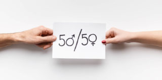Gender parity. Man and woman holding paper with text 50/50, zeros as female and male symbols, copy space La loi visant à accélérer l’égalité économique et professionnelle est définitivement publiée