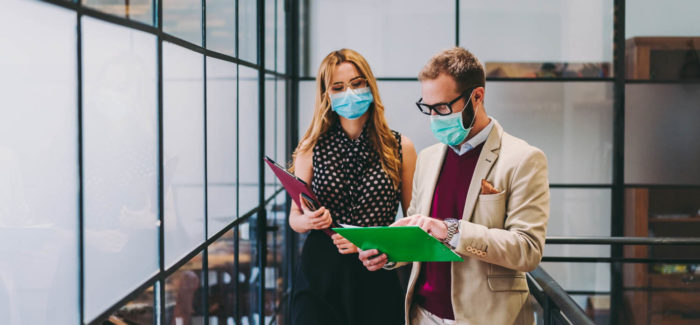 Businesspeople wearing masks in the office for illness prevention during COVID-19 pandemic Covid-19 : publication du protocole national sanitaire en entreprise, ce qui change au 1er septembre 2020