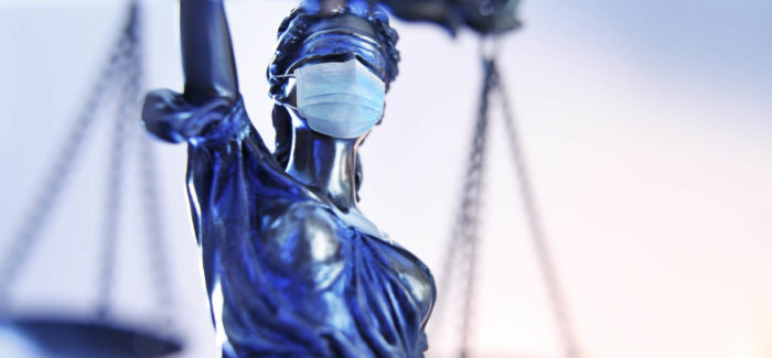 A close up of the the lady justice photographed from a very low camera angle wearing a protective face mask. Panorama du contentieux social : synthèse des décisions obtenues par CMS Francis Lefebvre Avocats