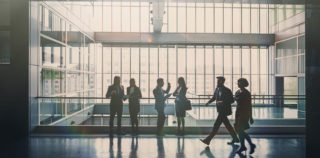Business people in lobby walking Imputation des déficits d’un groupe intégré sur une base élargie : précisions administratives