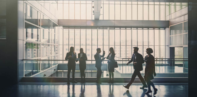 Business people in lobby walking Covid-19 : nouvelles règles applicables en entreprise à compter du 9 juin 2021