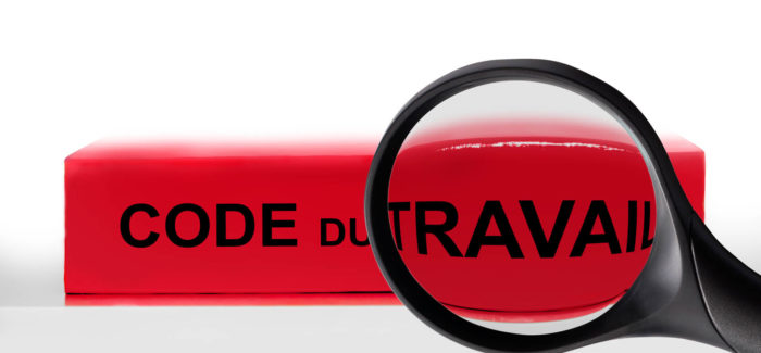 French labor code book and magnifying glass, labor code law reform in France concept Le chemin de croix du licenciement des salaries protégés : analyse des règles en vigueur