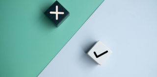 True and false symbols accept rejected on wood cubes for evaluation. Yes or No on wood cubes placed on a two colored background. Répartition des compétences entre le CSE central et les CSE d’établissement : l’éclairage de la Cour de cassation