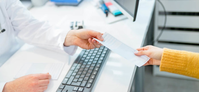 Elevated view of unrecognizable doctor passing prescription to female patient over the desk La rupture du contrat de travail pour inaptitude après refus d’une proposition de reclassement