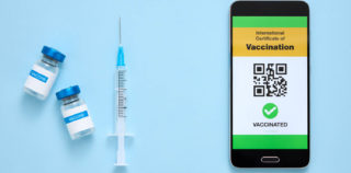 Coronavirus vaccination certificate or vaccine passport for travellers concept. Digital certificate, proof of coronavirus immunization. Top view. Covid-19 : nouvelles mesures de gestion de crise sous le signe de la vigilance