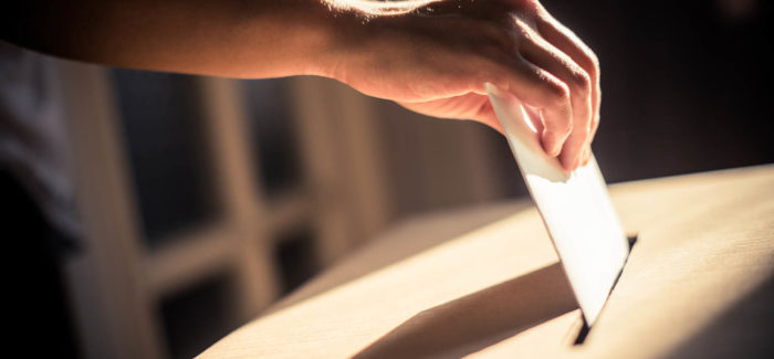 Conceptual image of a person voting, casting a ballot at a polling station, during elections. Protocole d’accord préélectoral : le nouveau formalisme du courrier d’invitation à négocier