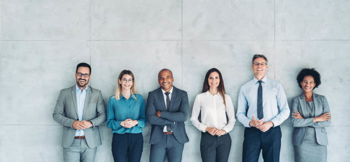 Multi-ethnic group of people in formal businesswear standing in a row Loi du 24 décembre 2021 visant à accélérer l’égalité économique et professionnelle