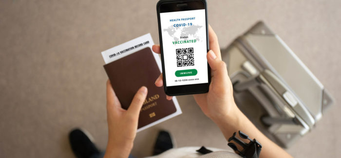 Selective focus, Smartphone on hand of traveler show health passport of vaccination certification in the airport. Online certificate of vaccinated coronavirus. Travel concept during Covid-19 pandemic. Pass sanitaire : les décrets d’application sont publiés !