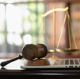 law legal technology concept. judge gavel on computer with scales of justice on desk of lawyer. La multiplication des demandes devant le Conseil de Prud’hommes (plus d’une dizaine) et leur montant élevé (582.000 euros au total) ne préjugent en rien de leur bien-fondé