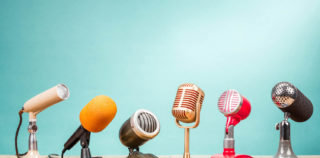 Retro old microphones for press conference or interview on table front gradient aquamarine background. Vintage old style filtered photo Harcèlement, CSP, témoignage anonyme, titre-restaurant : le point sur de récents arrêts de la Cour de cassation