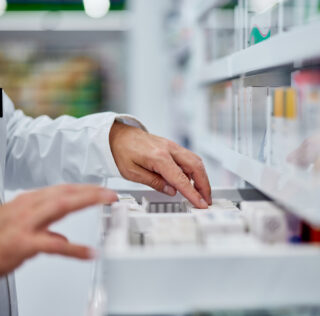 Male pharmacist choosing a medicine from the drawer, side view. Exercice d’une activité réglementée : n’omettez pas de vérifier que vos salariés sont en possession des diplômes nécessaires !