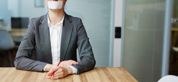 Voiceless busineswoman with her mouth stuck sitting by workplace Entretien préalable : faut-il informer le salarié de son droit de se taire ?