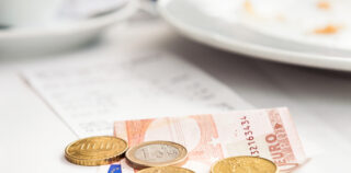 A Euro note and coins to pay a cafe breakfast bill. La cour d’appel de Versailles estime que les titres-restaurant relèvent des activités sociales et culturelles