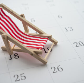 Red beach chair on white blank calendar background copy space. Annual leave travel period for relaxation concept. Period of paid time off (PTO) granted to employees by their employer. Droit Social + marque une pause estivale