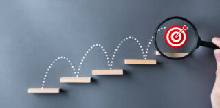 Unlock potential of business success stairs dart and dartboard targets magnifying glass with hand on gray background. Explore opportunities growth embrace steps to achieve ambitions and goal concept. L’Accord de Performance Collective (APC) : un outil juridique puissant, soumis à contrôle judiciaire de réalité