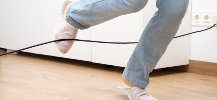 Close up of a woman legs stumbling with an electrical cord at home La difficile contestation du caractère professionnel de l’accident déclaré en situation de télétravail