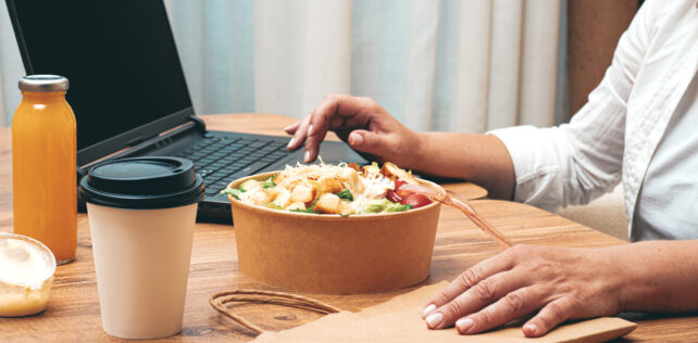 a woman is working on a laptop at home, there is food on the table, salad, coffee and juice, delivery, work at home, La Cour de cassation consacre le droit des télétravailleurs aux titres-restaurant au nom du principe d’égalité de traitement